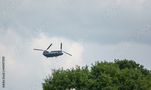 RAF Boeing Chinook UH-1 helicopter flying low in a cloudy blue grey and white summer sky