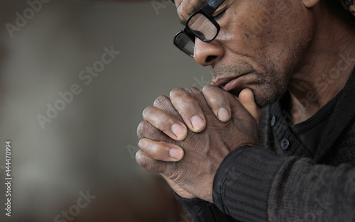 man praying to god with hands together worshiping God Caribbean man praying with people stock image stock photo photo