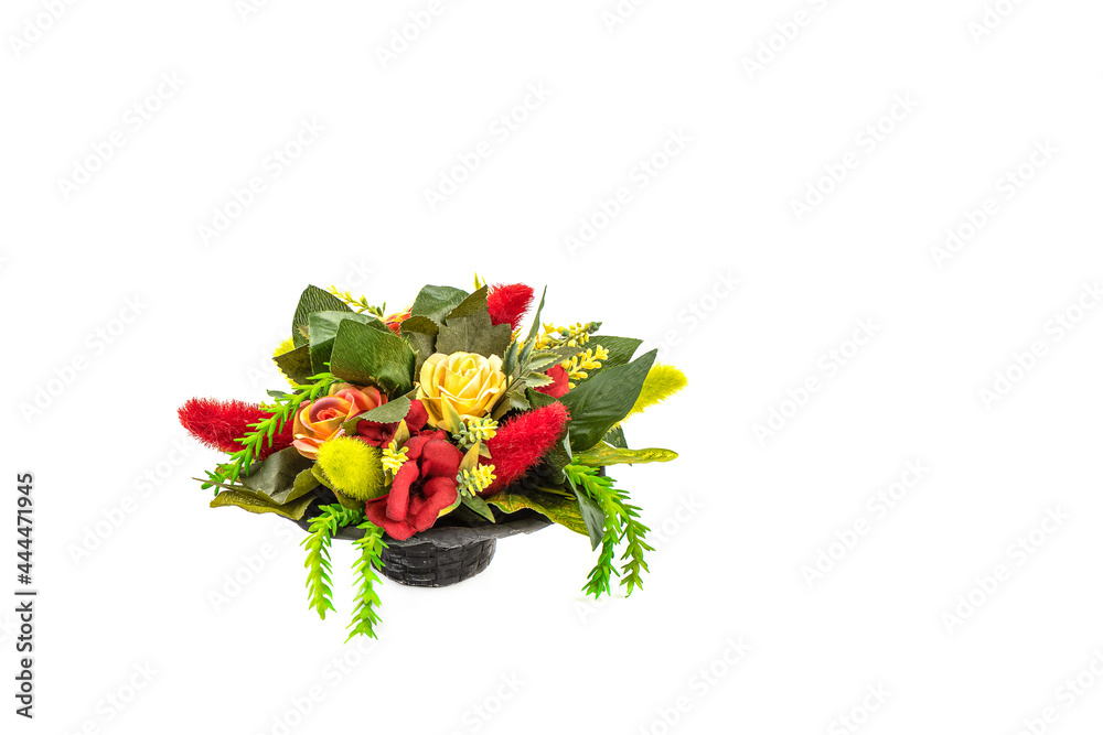 Obraz premium Artificial blooming flowers and grass in a basket isolated on white with place for text.