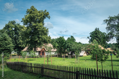 Old farm buildings and a court surrounded by trees in a countryside scenery on a beautiful  sunny dummer day. Zwierzyniec  Roztocze  Poland.