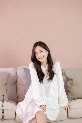 At cozy living room happy woman sitting on sofa. female enjoy lazy weekend or vacation