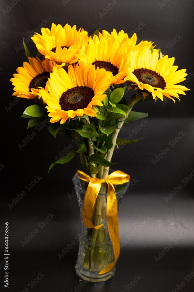 Fototapeta premium Bouquet of bright sunflowers against black background