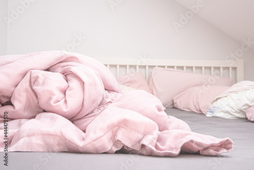 Pink blankets on a grey and white bed.