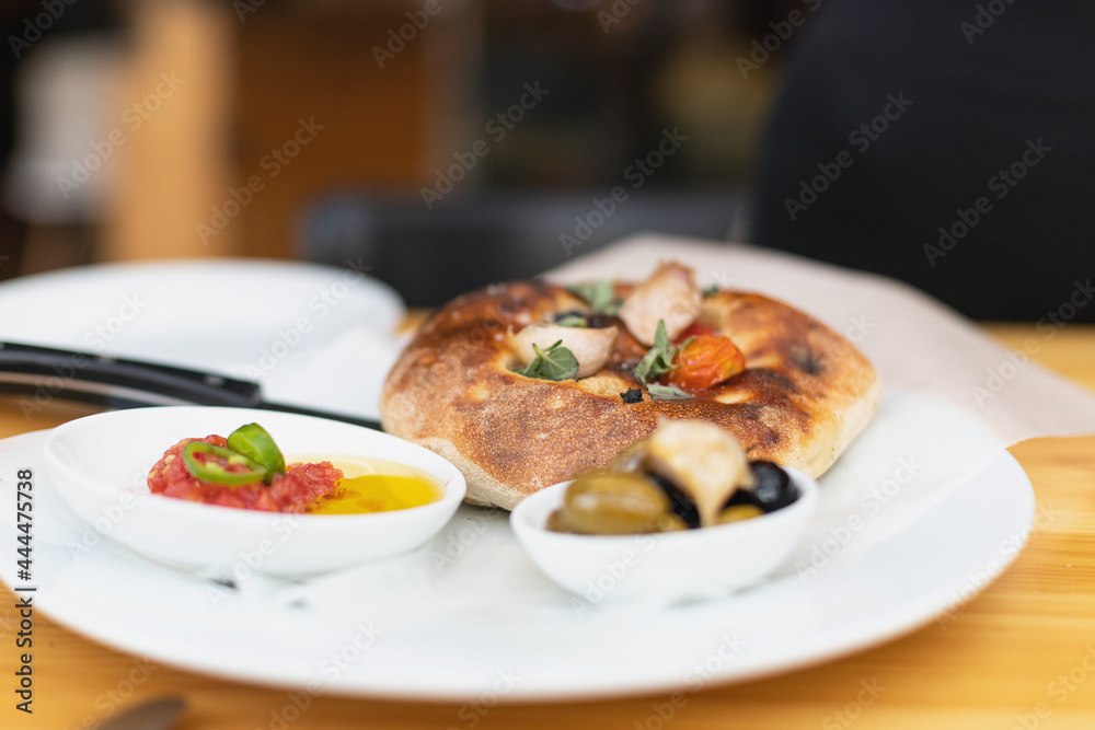 Italian focaccia with cherry tomatoes, thassos olives, oregano, olive oil and sea salt. served with salsa and olives Italian focaccia with cherry tomatoes, thassos olives, oregano, olive oil and sea salt. served with salsa and olives