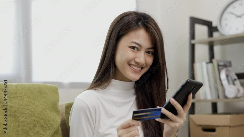 Shopping online. Young asian teenage girl input the serial number of credit card to smartphone for shopping payment. Buy item online delivery at home. Smiling female feeling happy. Shopping online. Young asian teenage girl input the serial number of credit card to smartphone for shopping payment. Buy item online delivery at home. Smiling female feeling happy.