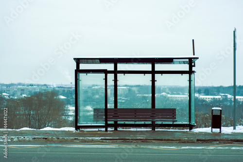 Empty Bus Stop in winter city. empty stop in the cold snowy weather. copy space. empty street. Winter day. public transport. Stop without people, without passengers. bus stop sign. bench