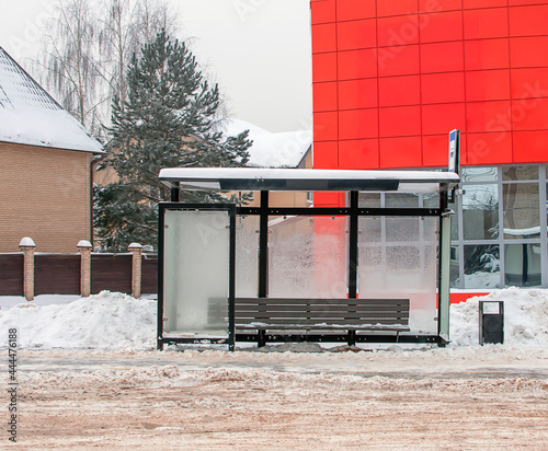 Empty public transport stop in the city. Bus stop on a snowy winter day. City street. Copy space 