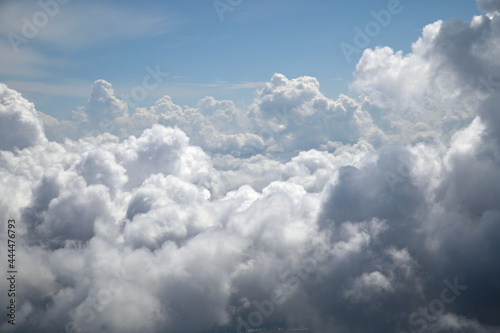 Fototapeta Naklejka Na Ścianę i Meble -  Lush cumulus clouds visible from the aircraft through the porthole