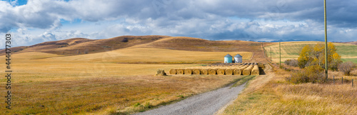 Rural Alberta Canadian prairie grassland landscape countryside background panorama. Beautiful farmer's field and grain silos with hay bales wallpaper  photo