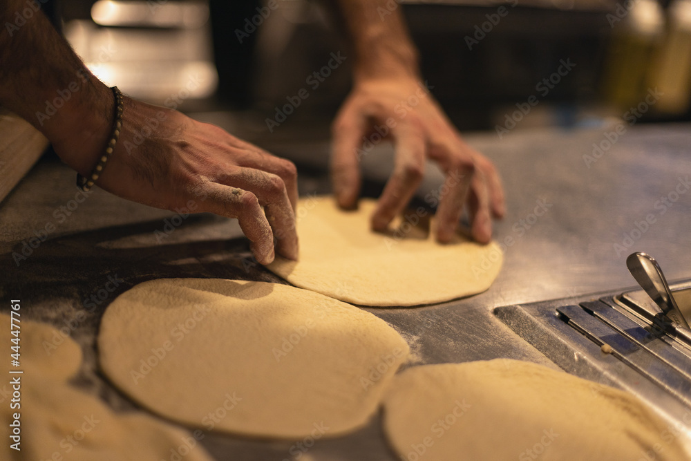 the cook rolls out the dough. Table in flour the cook rolls out the dough. Table in flour