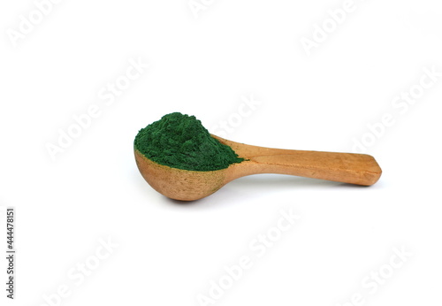 Organic spirulina algae powder in a wooden spoon isolated on white. Organic spirulina powder. Spirulina is a superfood used as a food supplement source of vitamin protein and beta carotene.