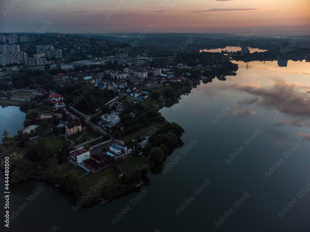 Scenic aerial sunrise time on wide calm river with mirror surface. Early morning, dawn in Kharkiv Zhuravlivskyy Hidropark from sky. Drone photography