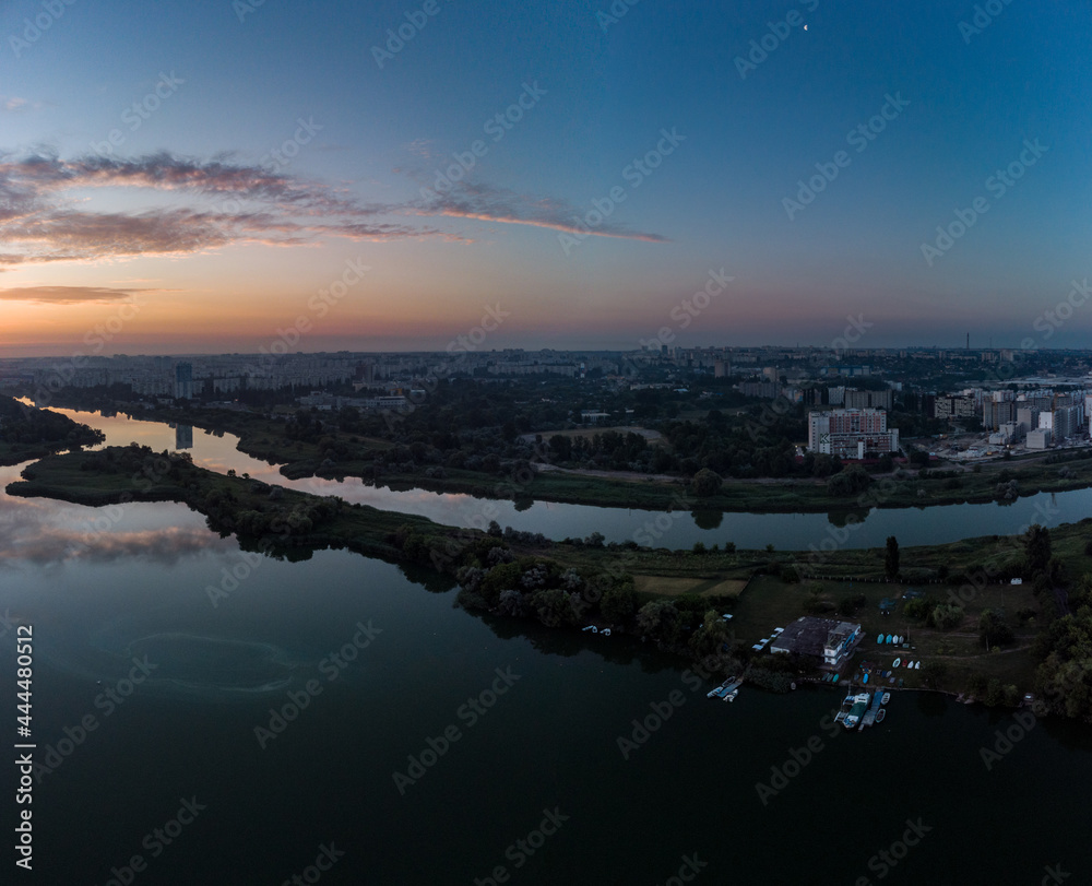 Scenic aerial sunrise time on wide calm river with channel and mirror surface. Early morning, dawn in Kharkiv Zhuravlivskyy Hidropark from sky. Drone photography