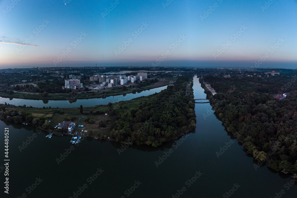 Scenic aerial sunrise time on wide calm river with channels and mirror surface. Early morning, dawn in Kharkiv Zhuravlivskyy Hidropark from sky. Drone photography