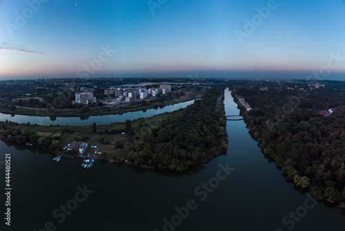 Scenic aerial sunrise time on wide calm river with channels and mirror surface. Early morning  dawn in Kharkiv Zhuravlivskyy Hidropark from sky. Drone photography