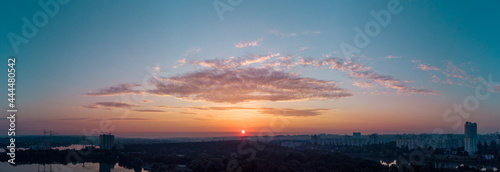 Scenic aerial panorama sunrise sky with clouds reflecting in mirror water surface on wide river. Early morning, dawn in Kharkiv Zhuravlivskyy Hidropark from sky. Drone photography
