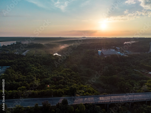 Aerial sunrise morning skyscape. Multistory buildings and greenery with fog at dawn in nice pastel light. View on Sokilnyky with Derevianka st bridge across Sarzhyn Yar in Kharkiv city.