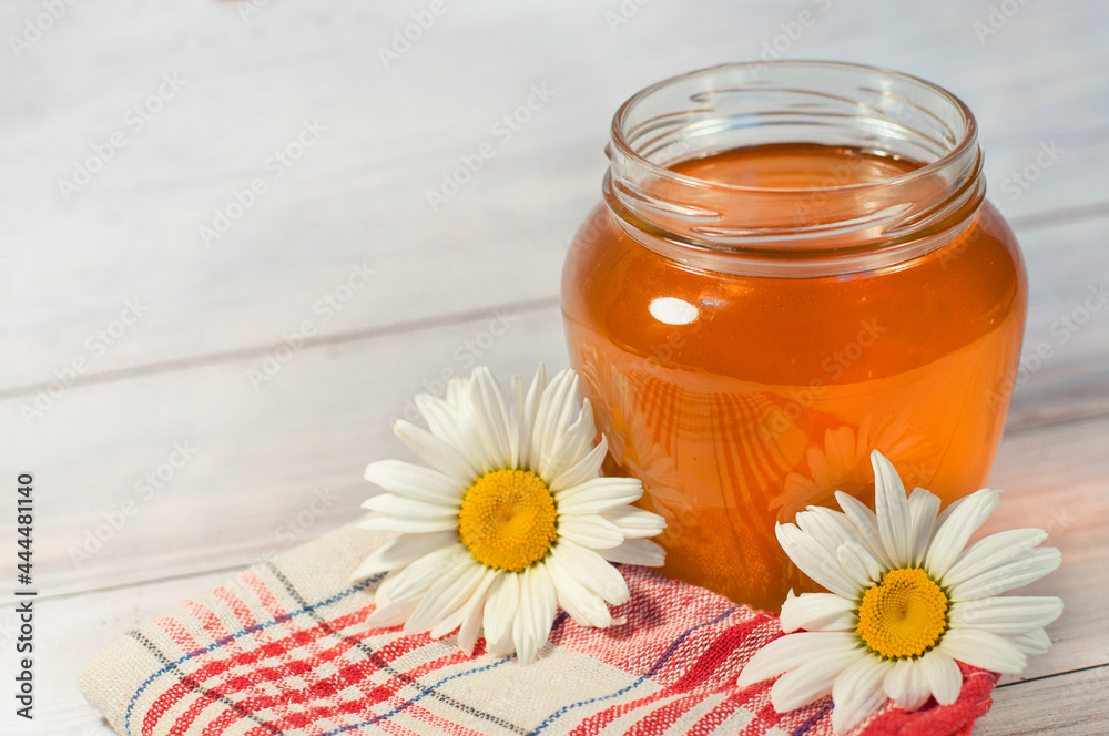 fresh honey in a transparent jar on a wooden background. High quality photo fresh honey in a transparent jar on a wooden background. High quality photo
