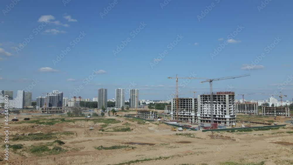 Construction of a modern city block. The concrete frames of the buildings are visible at the construction site. Construction cranes are working. Aerial photography. Construction of a modern city block. The concrete frames of the buildings are visible at the construction site. Construction cranes are working. Aerial photography.