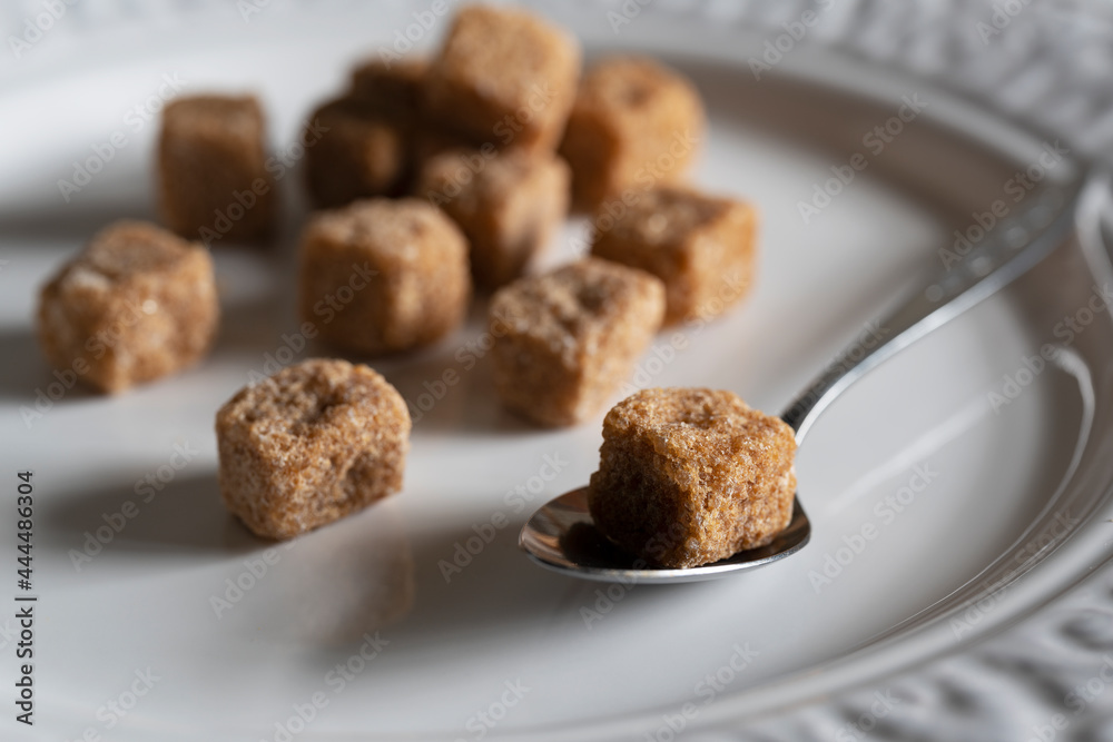 Brown cane sugar cubes on a white plate. Brown cane sugar cubes on a white plate.