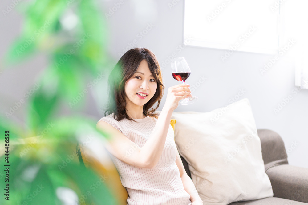 家でワインを楽しむ若い女性