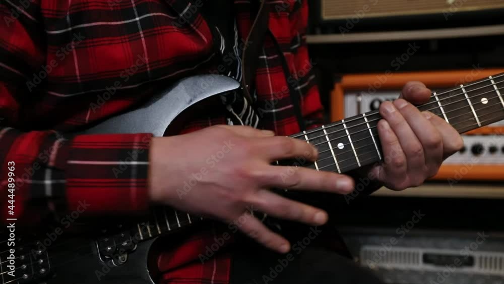 Close-up video of playing bass guitar. Guitarist plays a musical instrument in a sound recording studio.