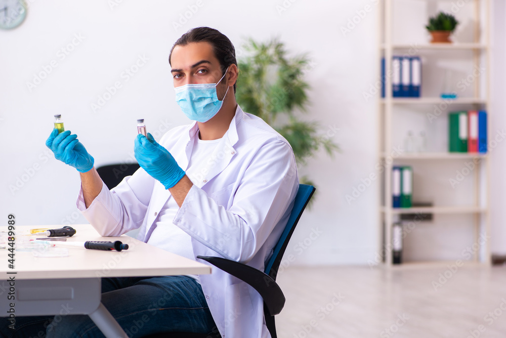 Young male chemist working in the lab during pandemic