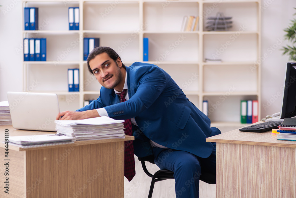 Young male employee in multitasking concept Young male employee in multitasking concept