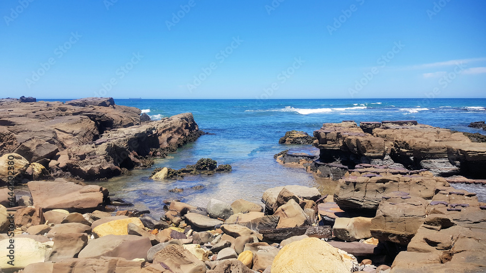 Waves crashing onto the rocky shoreline at Dudley Beach New South Wales Australia