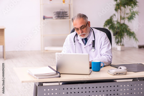 Aged male doctor working in the clinic