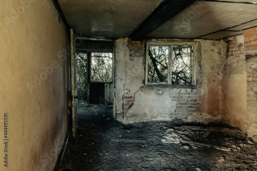 A decaying room in an abandoned ruined house. With broken doors and windows. © Dave