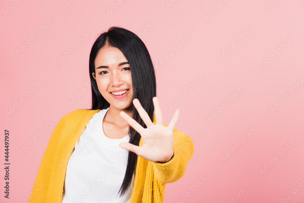 Asian portrait beautiful cute young woman teen smiling doing show stop sign gesture with palm of hand but happy face studio shot isolated on pink background, female doubt with copy space Asian portrait beautiful cute young woman teen smiling doing show stop sign gesture with palm of hand but happy face studio shot isolated on pink background, female doubt with copy space