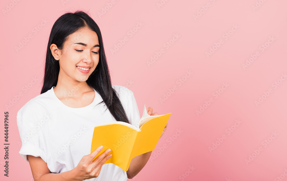 woman teenage smiling holding a book and reading woman teenage smiling holding a book and reading