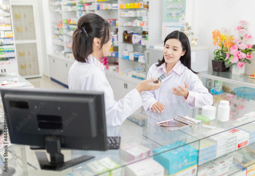 two asian pharmacists talk about drug information in drugstores, they exchange knowledge and feeling happy, happy healthcare organization