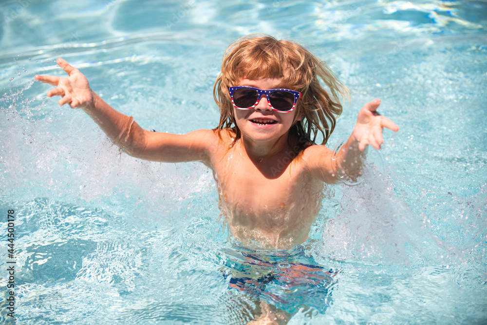 Cute child boy swim in swimming pool, summer water background with copy space. Cute boy in the water playing with water. Boy splashing in swimming pool having fun leisure activity open arms.