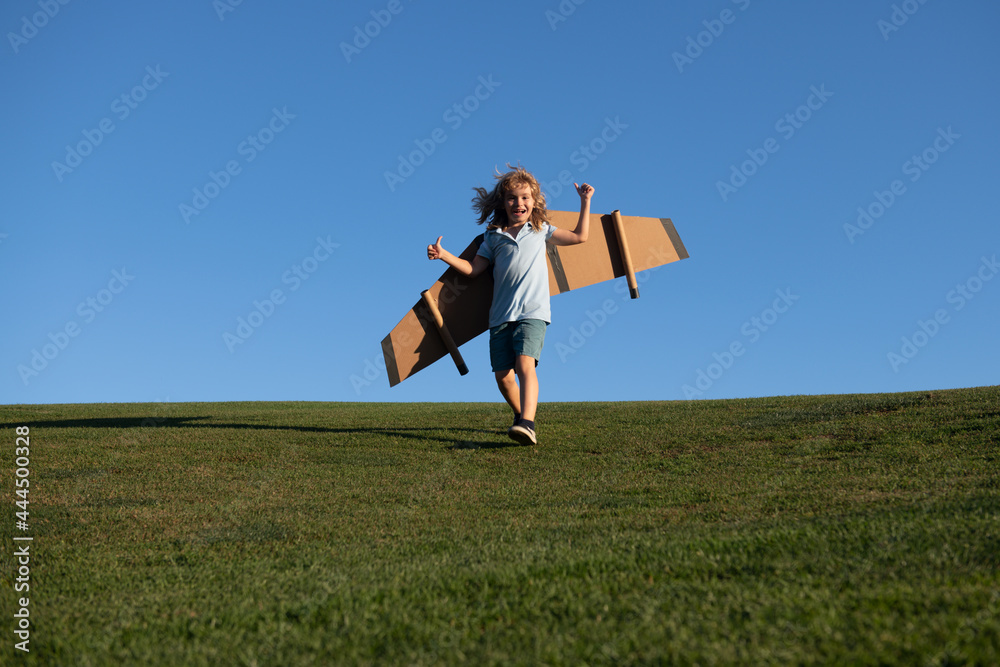 Child boy jumping and running with toy airplane wings. Dream of becoming a pilot. Superhero flying. Child boy jumping and running with toy airplane wings. Dream of becoming a pilot. Superhero flying.