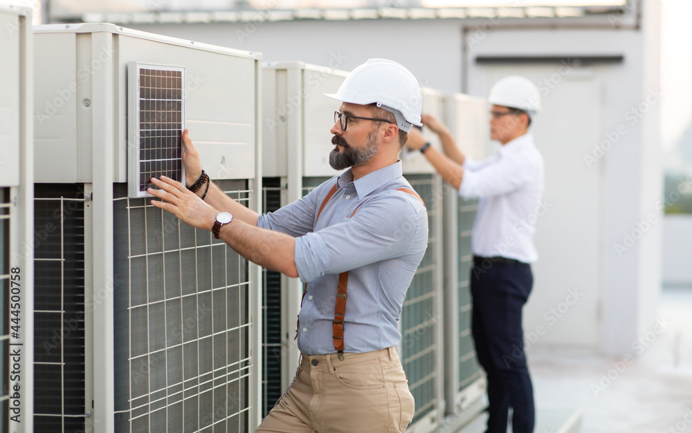 Portrait of Technician Electrical Engineer at rooftop building. Clean and green alternative energy concept. Portrait of Technician Electrical Engineer at rooftop building. Clean and green alternative energy concept.