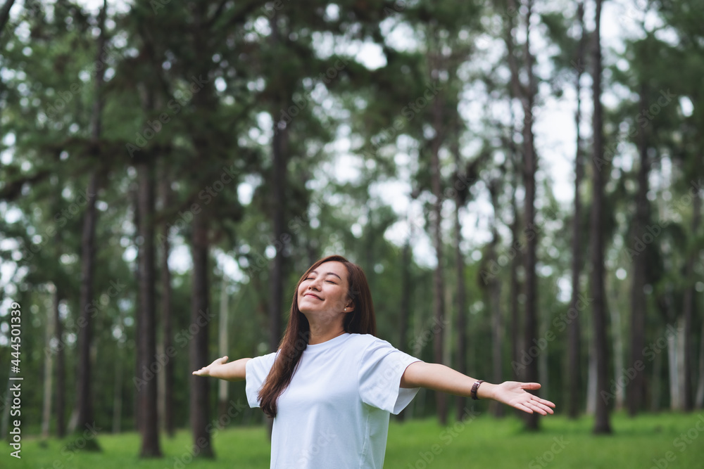 Portrait image of a happy young asian woman with arms opening in the park Portrait image of a happy young asian woman with arms opening in the park