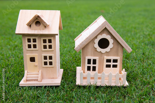Neighbors house concept. Toy model house in he middle of large grass meadow field. Mortgage payment, big yard. © Volodymyr