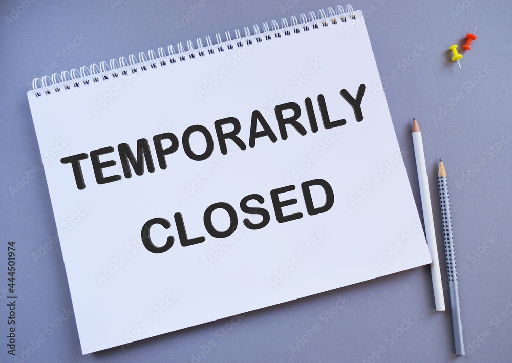 Temporarily Closed text written on a notebook with pencils, business concept