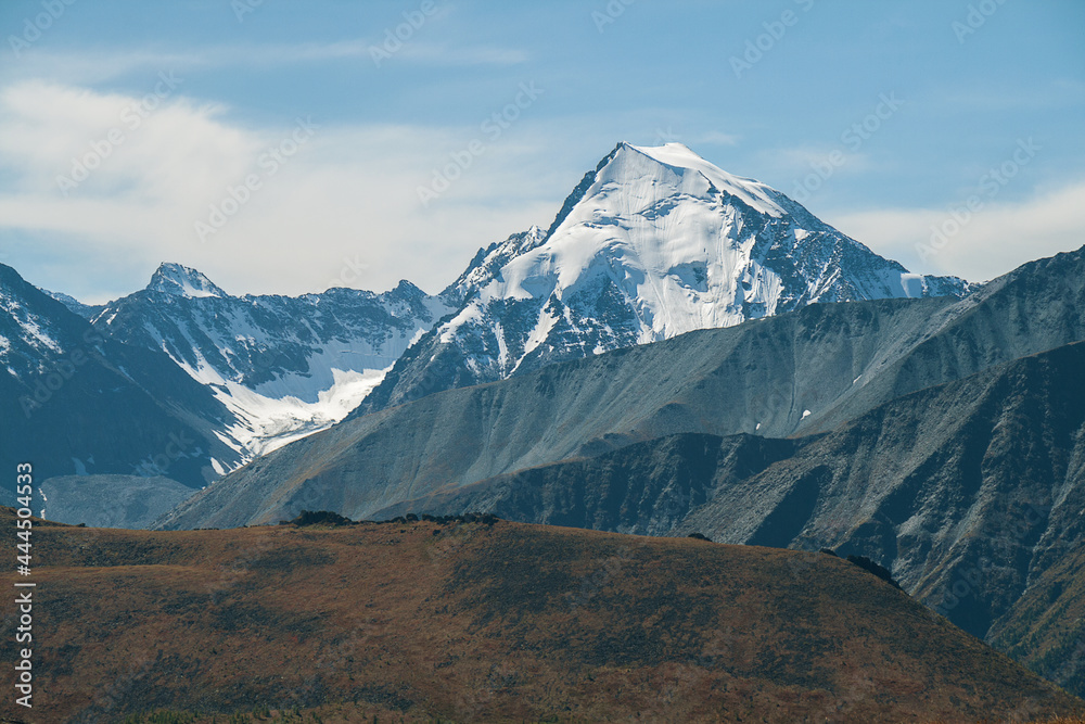 Fototapeta premium Mountain peak covered with snow. Mystical drawing of a face on the mountain.