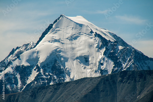 Mountain peak covered with snow. Mystical drawing of a face on the mountain.