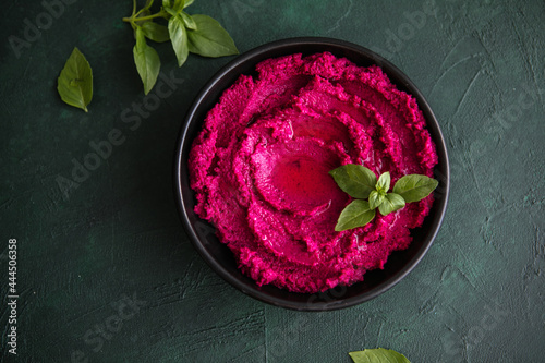 Humus Bowl. Red beetroot hummus with fresh vegetables, olive oil on table