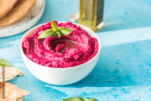 Humus Bowl. Red beetroot hummus with fresh vegetables, olive oil on table