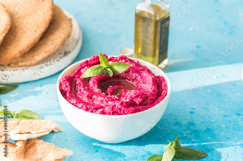 Humus Bowl. Red beetroot hummus with fresh vegetables, olive oil on table