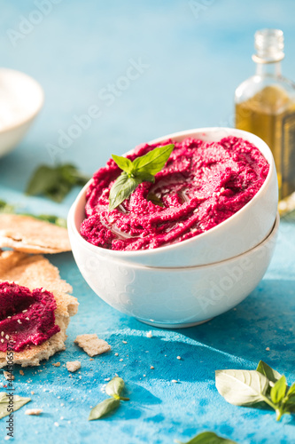 Humus Bowl. Red beetroot hummus with fresh vegetables, olive oil on table