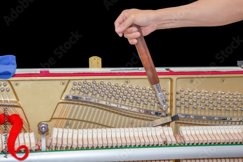 Piano tuner tuning upright piano photo
