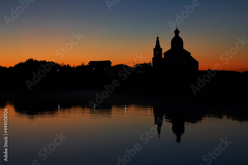 Silhouette of the Church of Elijah the Prophet at sunset in Suzdal. Nature background sunset on the river.