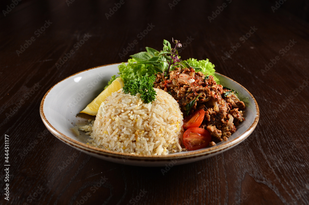 Thai style egg fried rice with spicy minced meat quorn and sliced of lemon asian vegetarian menu on wood table Thai style egg fried rice with spicy minced meat quorn and sliced of lemon asian vegetarian menu on wood table