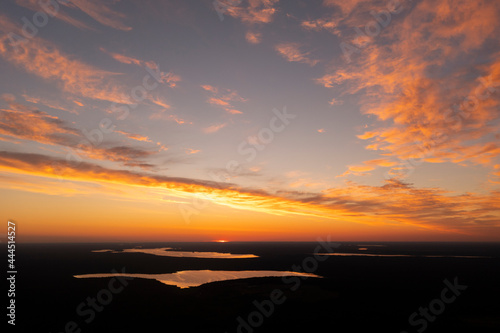 Aerial view of a sunset sky background. Aerial Dramatic gold sunset sky with evening sky clouds over the lake. Stunning sky clouds in the sunset. Sky landscape. Aerial photography. © Aleksei